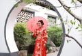 Young, beautiful and elegant Chinese woman wearing a typical Chinese bride`s silk red dress, adorned with golden phoenix and drago Royalty Free Stock Photo