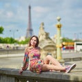 Young woman sitting near the Eiffel tower in Paris Royalty Free Stock Photo