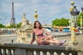 Young woman sitting near the Eiffel tower in Paris Royalty Free Stock Photo