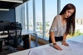 Young, beautiful and empowered entrepreneurial woman architect, working in the office on her architectural drawings and plans Royalty Free Stock Photo