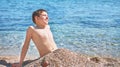 Young beautiful european caucasian boy plays on beach sand pebble sea Montenegro Boka kotorska Royalty Free Stock Photo