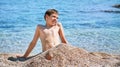 Young beautiful european caucasian boy plays on beach sand pebble sea Montenegro Boka kotorska Royalty Free Stock Photo