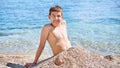 Young beautiful european caucasian boy plays on beach sand pebble sea Montenegro Boka kotorska Royalty Free Stock Photo