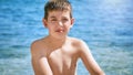 Young beautiful european caucasian boy plays on beach sand pebble sea Montenegro Boka kotorska Royalty Free Stock Photo