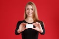 A girl holding between her fingers a business card and smiling. Royalty Free Stock Photo