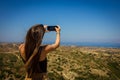 Young beautiful european girl travels, takes a photo on smartphone Royalty Free Stock Photo