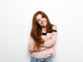 Young beautiful excited woman with bated breath, with crossed hands gorgeous natural ginger hair, blank copy space on white backgr