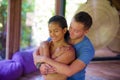 Young beautiful and exotic Asian Balinese woman receiving body healing Thai massage by attractive Caucasian masseur man at