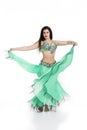 Young beautiful exotic eastern women performs belly dance in ethnic green dress. Isolated on white background Royalty Free Stock Photo