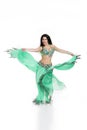 Young beautiful exotic eastern women performs belly dance in ethnic green dress. Isolated on white background Royalty Free Stock Photo