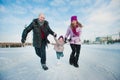 Young beautiful family in bright clothes winter fun jumping and running, snow, lifestyle, winter holidays