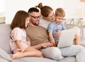 Young beautiful family using modern technologies while spending time together at home Royalty Free Stock Photo