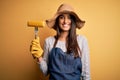 Young beautiful farmer woman wearing apron and hat holding fork with cob corn with a happy face standing and smiling with a Royalty Free Stock Photo