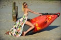 Young beautiful fashion model in colorful dress and sunglasses posing at the beach Royalty Free Stock Photo