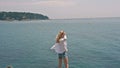 Young beautiful fashion model woman raises her arms up on the beach