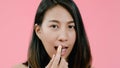 Young beautiful fashionable Asian woman applying lips makeup with cosmetic brush in casual clothing over pink background studio Royalty Free Stock Photo