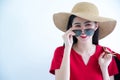 Young Beautiful Fashionable Asian Woman Holding Shopping Bags Wearing Red Dress, Sunglasses And Hat Over White Background Studio