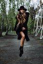 Young beautiful fashionable woman in hat levitate, long hair