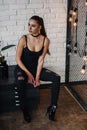 Beautiful fashionable woman at loft style room with white bricks wall and black iron net. Attractive girl with perfect