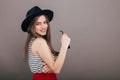 Young beautiful fashionable woman with trendy makeup in black hat and glasses on the grey background . Model looking at camera, w Royalty Free Stock Photo