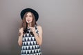 Young beautiful fashionable woman with trendy makeup in black hat and glasses on the grey background . Model looking at camera, w Royalty Free Stock Photo