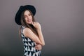 Young beautiful fashionable woman with trendy makeup in black hat and glasses on the grey background . Model looking at camera, w Royalty Free Stock Photo