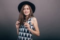 Young beautiful fashionable woman with trendy makeup in black hat and glasses on the grey background . Model looking at camera, w Royalty Free Stock Photo