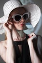 Young beautiful fashionable woman with trendy makeup. Model looking at camera, wearing stylish eyeglasses, hat. Female fashion, be Royalty Free Stock Photo