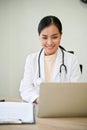 Young beautiful female doctor working with laptop computer in her clinic Royalty Free Stock Photo