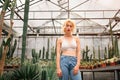 Perky female fashion model posing among cacti