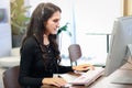 Young beautiful female with headphones working at call center service desk consultant, talking with the customer on hands-free Royalty Free Stock Photo