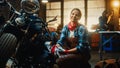 Young Beautiful Female Mechanic is Working on a Custom Bobber Motorcycle. Talented Girl Wearing a Royalty Free Stock Photo