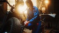 Young Beautiful Female Mechanic is Working on a Custom Bobber Motorcycle. Talented Girl Wearing a Royalty Free Stock Photo