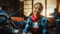 Young Beautiful Female Mechanic is Working on a Custom Bobber Motorcycle. Talented Girl Wearing a Royalty Free Stock Photo