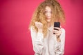 Young beautiful female with messy hair holding mobile phone Royalty Free Stock Photo