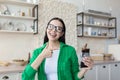 Young beautiful female nutritionist in glasses and green shirt advertises and recommends chocolate Royalty Free Stock Photo