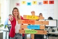 A young beautiful female office worker is holding a sign with company slogans and posing for a photo in a pleasant atmosphere in