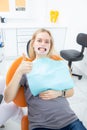 Young beautiful female patient with retractor in dentist office looking at camera