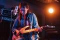 Young beautiful female performer with guitar singing and rehearsing in a recording studio Royalty Free Stock Photo