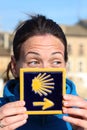 Young beautiful female pilgrim's portrait posing with the typical Camino de Santiago blue tile Royalty Free Stock Photo