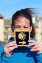 Young beautiful female pilgrim's portrait posing with the typical Camino de Santiago blue tile Royalty Free Stock Photo