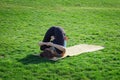 Young beautiful fit woman doeing yoga asans on the green grass with yoga mat Royalty Free Stock Photo