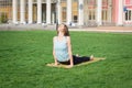 Young beautiful fit woman doeing yoga asans on the green grass with yoga mat Royalty Free Stock Photo