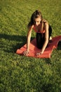 Fitness girl with ponytail rolling pink mat Royalty Free Stock Photo