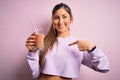 Young beautiful fitness woman drinking protein chocolate milkshake before gym with surprise face pointing finger to himself