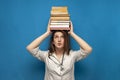 Young beautiful funny girl the nurse holds many books on a blue background and is surprised, the student is studying in a medical Royalty Free Stock Photo