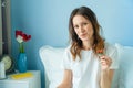 Young beautiful funny woman eats strawberry in bed for breakfast