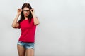 A young, beautiful girl adjusts her glasses. Isolated on a light background. Different human emotions, feelings of facial Royalty Free Stock Photo