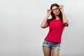 A young, beautiful girl adjusts her glasses. Isolated on a light background. Different human emotions, feelings of facial Royalty Free Stock Photo