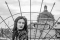 Young beautiful girl on a background of a fence and a dome of a temple during walk small streets of an old city of Lviv Royalty Free Stock Photo